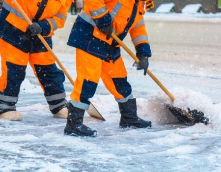 Communal services workers sweep snow from road in winter, Cleaning city streets and roads during snowstorm. Moscow, Russia